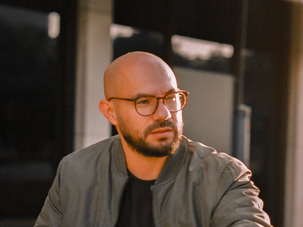 D at sunset in a bomber jacket, sitting outside — thecomebackstack.com hero portrait